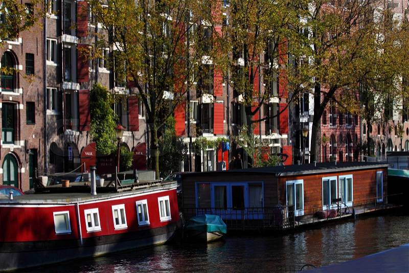 Quiet Amsterdam canal with house boats , stock photo