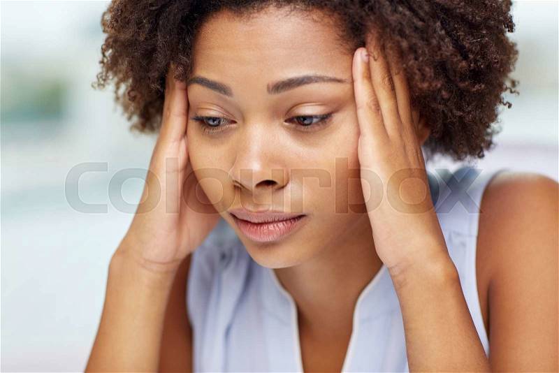 People, emotions, stress and health care concept - unhappy african american young woman touching her head and suffering from headache, stock photo