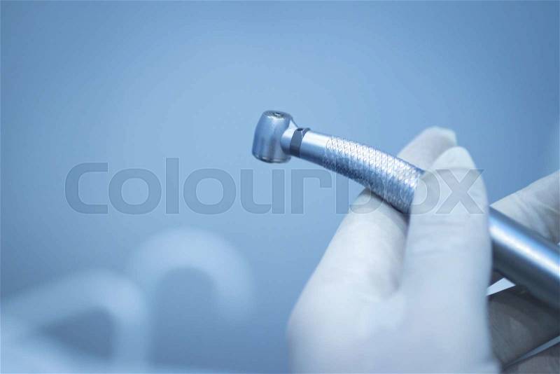 Dental instrumentation dentist drill tooth dental cleaning tool in the hand of dentist in dentists surgery clinic artistic color photo with shallow depth of focus, stock photo
