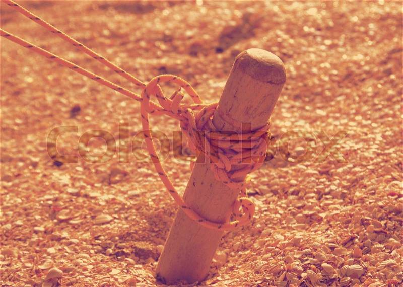 Wooden peg tent tied yellow solid thread, and scored in the sand, stock photo