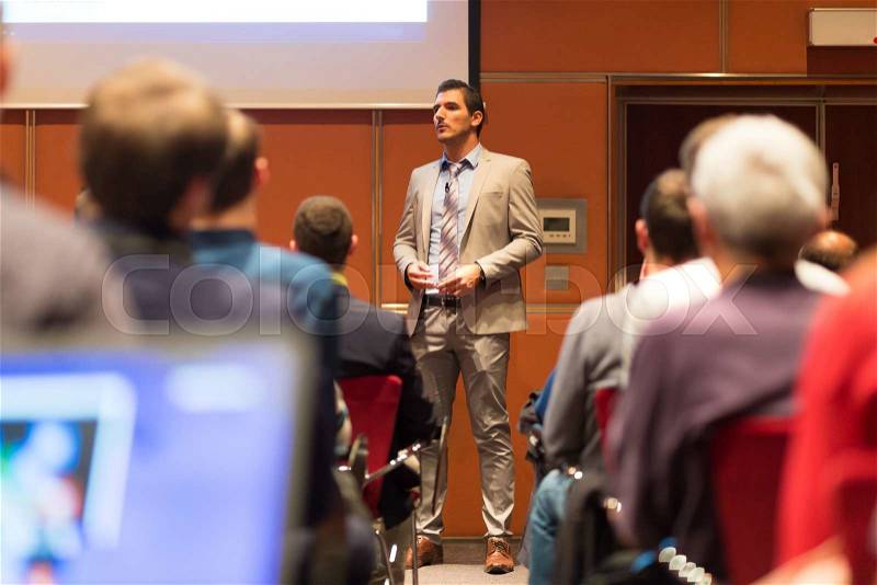 Speaker Giving a Talk at Business Meeting. Audience in the conference hall. Business and Entrepreneurship concept, stock photo