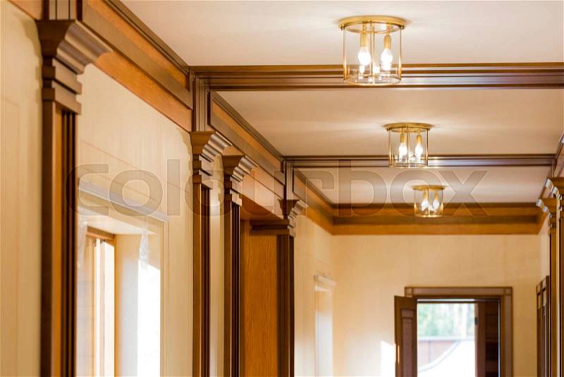 Interior corridor in ecological house.Illuminated light bulb on the ceiling.The wide windows with views of green garden. Design facilities new and modern, stock photo