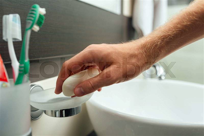 Man takes a soap to wash hands, stock photo