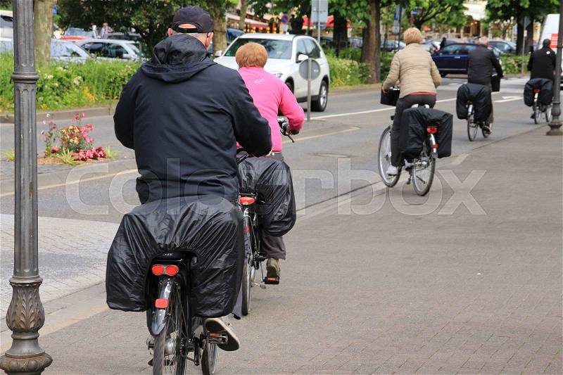 A group of retired bikers are cycling in one of the streets in the city Cochem in Germany in spring, stock photo