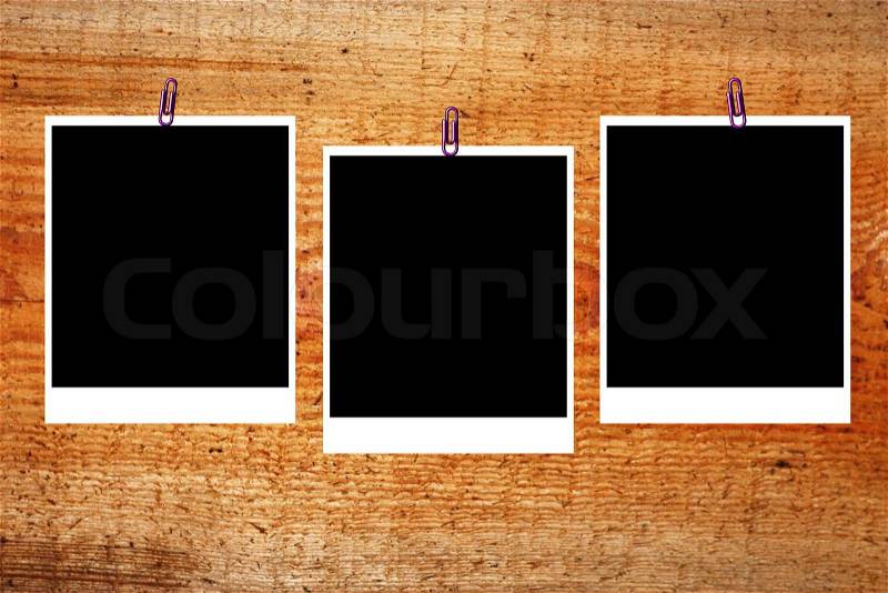 Set of three old blank polaroids frames lying on a wood surface, stock photo