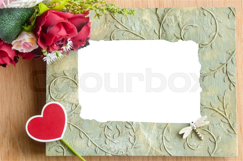 Blank photo frame and red rose wth heart shape red tag on wooden background, stock photo