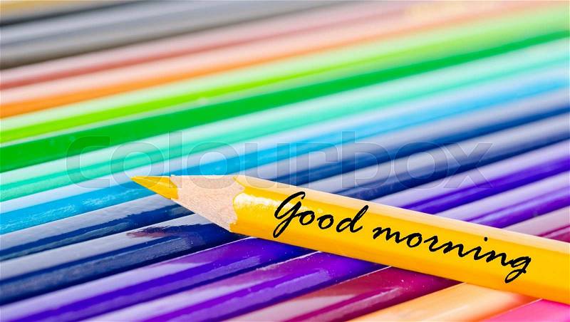Good morning wording with yellow pencil on many color pencils background, stock photo