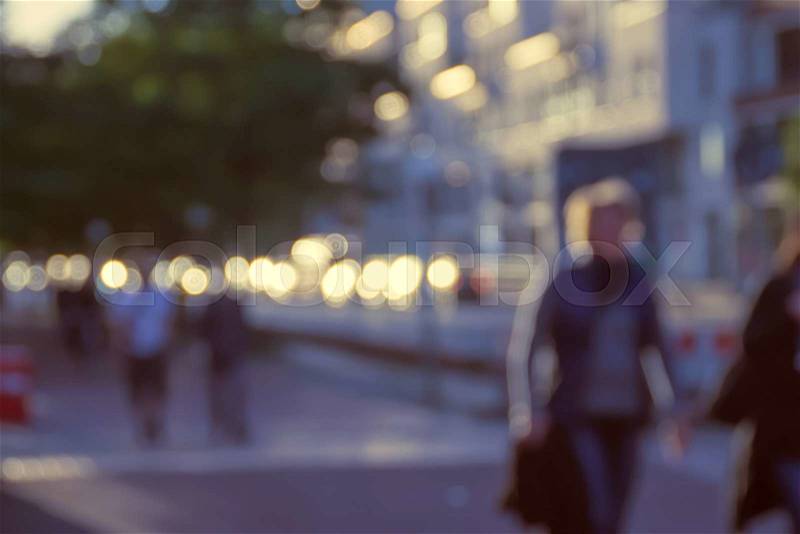 Blurred image of people walking in the street at evening, stock photo