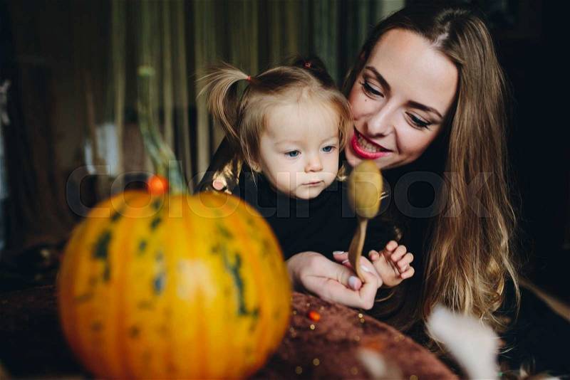 Mother and daughter playing together at home on Halloween, stock photo