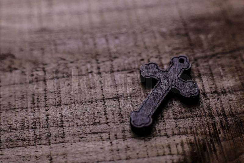 Wooden cross lying on the rustic wooden background, stock photo