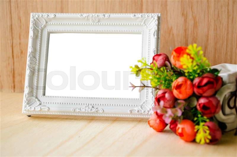 Flowers vase and vintage white picture frame on wooden desktop, clipping path, stock photo