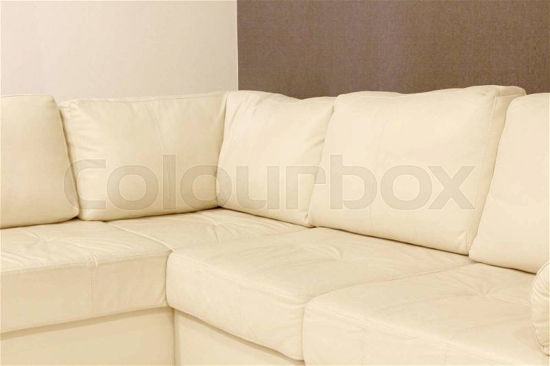 Modern white corner leather sofa taken closeup, stock photo