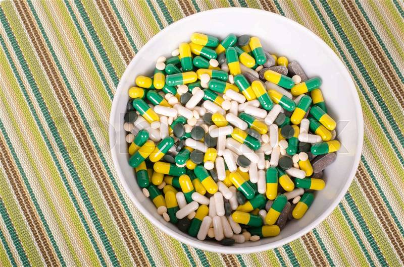 Plate of pills on striped cloth isolated, concept diet, diseases, stock photo