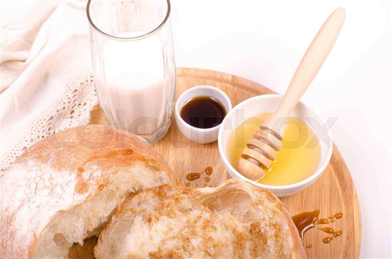 Bread with honey, milk on wood and white background, stock photo