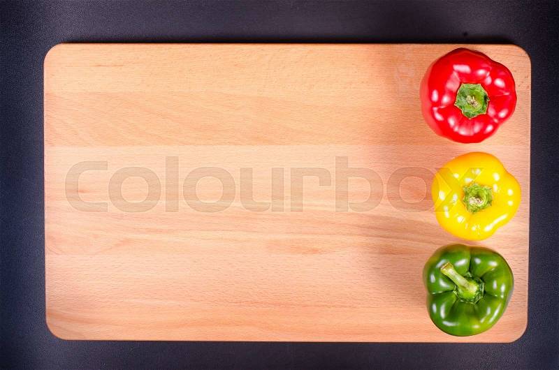 Colorful traffic light paprika on wooden background. Summer frame, stock photo