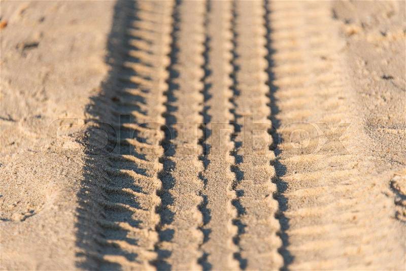 Car wheel tires print footprint on the beach gray sand , stock photo