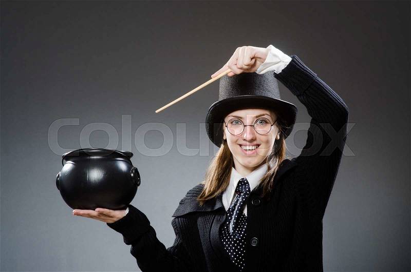 Harry Potter girl with magic stick and pot against gray, stock photo