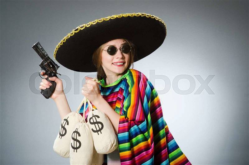 Girl in mexican poncho holding handgun and money sacks against gray, stock photo