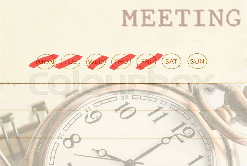 Close up meeting date on diary with pocket watch, stock photo