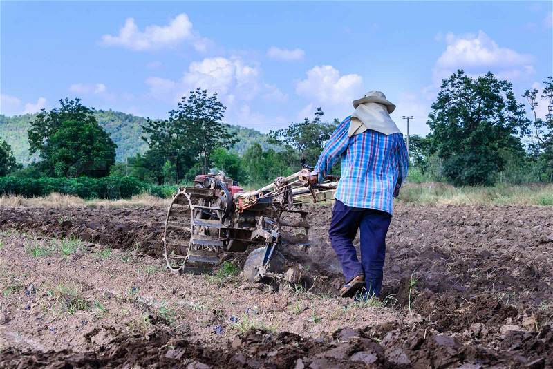 Thai farmer using walking tractors for cultivated soil for prepare plantation, stock photo