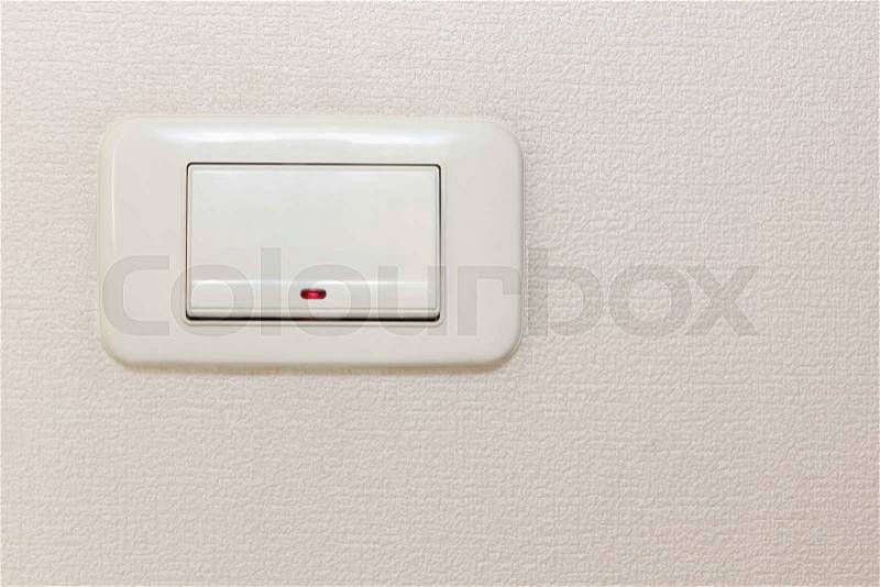 Light switch on beige wall taken closeup, stock photo