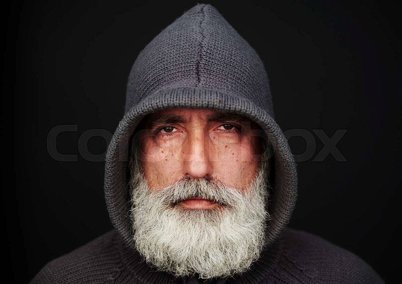Portrait of senior man in knitted jacket over black background. landscape orientation, stock photo