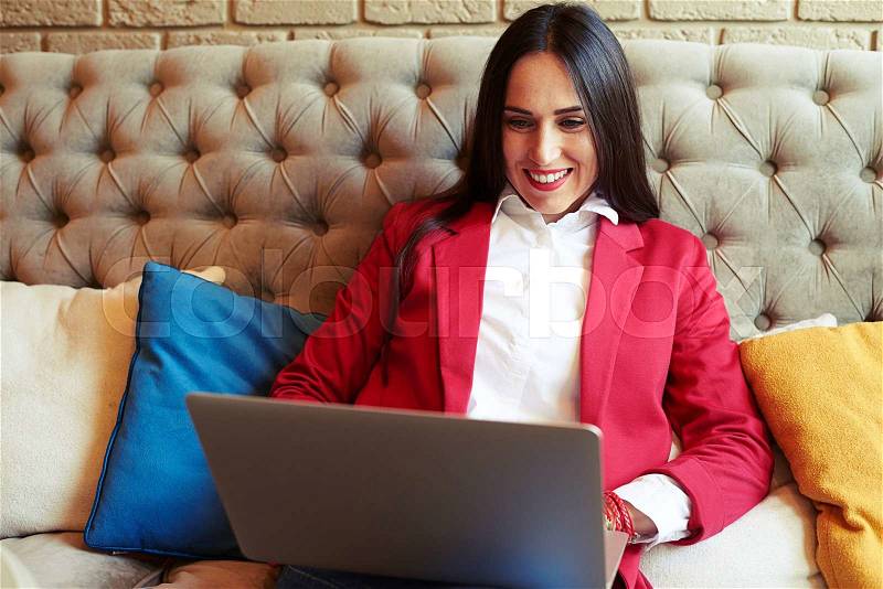 Smiley businesswoman resting with laptop on sofa , stock photo