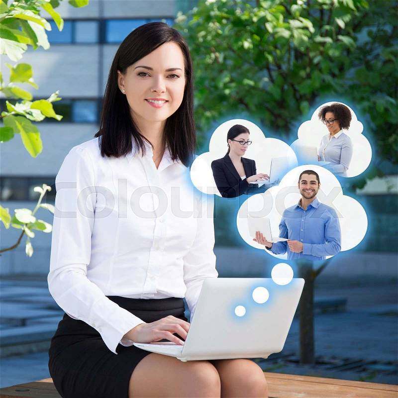 E-commerce and internet concept - happy business woman with laptop and clouds with her business partners, stock photo