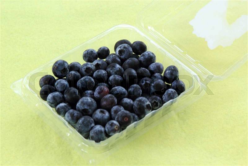 Blueberries in a Plastic Box on the table, stock photo