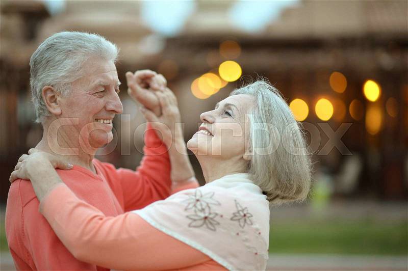Senior couple resting at the resort during vacation on dance floor, stock photo