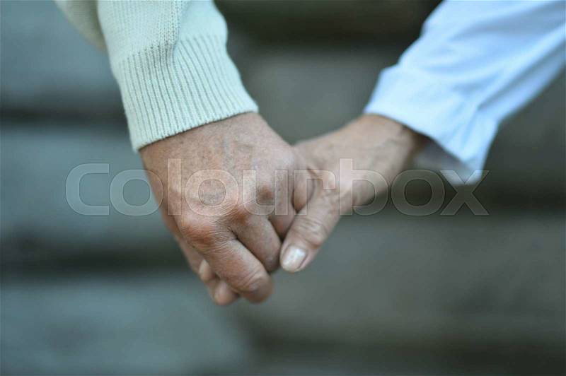 Portrait of a elderly couple holding hands close up, stock photo