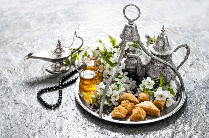 Islamic holidays food with decoration. Ramadan kareem. Eid mubarak. Oriental hospitality concept. Tea glasses and pot, traditional delight baklava, stock photo