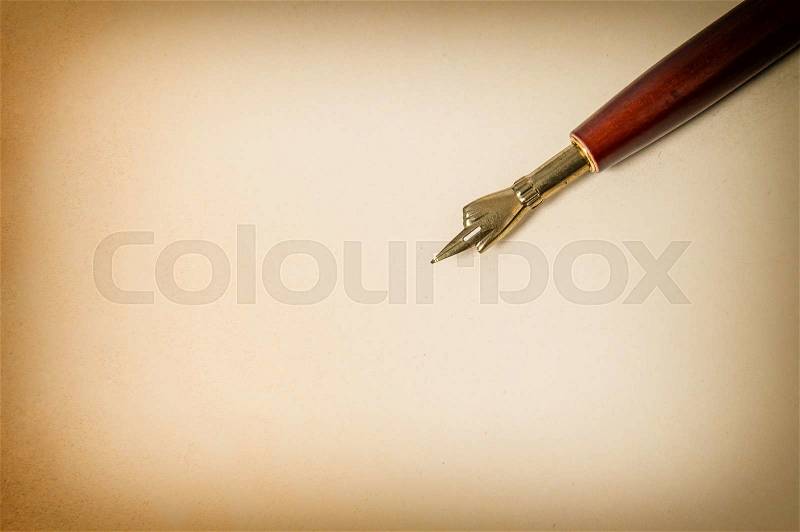Antique ink pen on grungy paper texture. Vintage background with space for your text. Retro style toned picture, stock photo