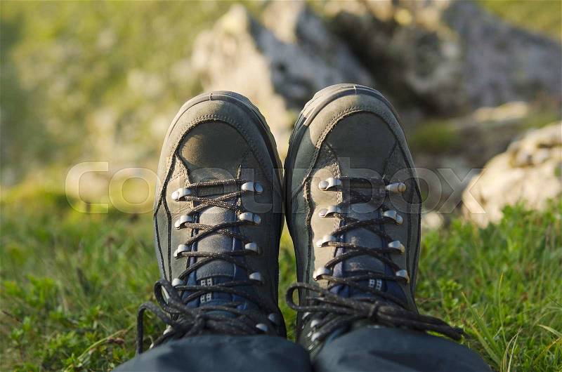 Trekking boots in the mountains against precipice, travel healthy active lifestyle background, stock photo