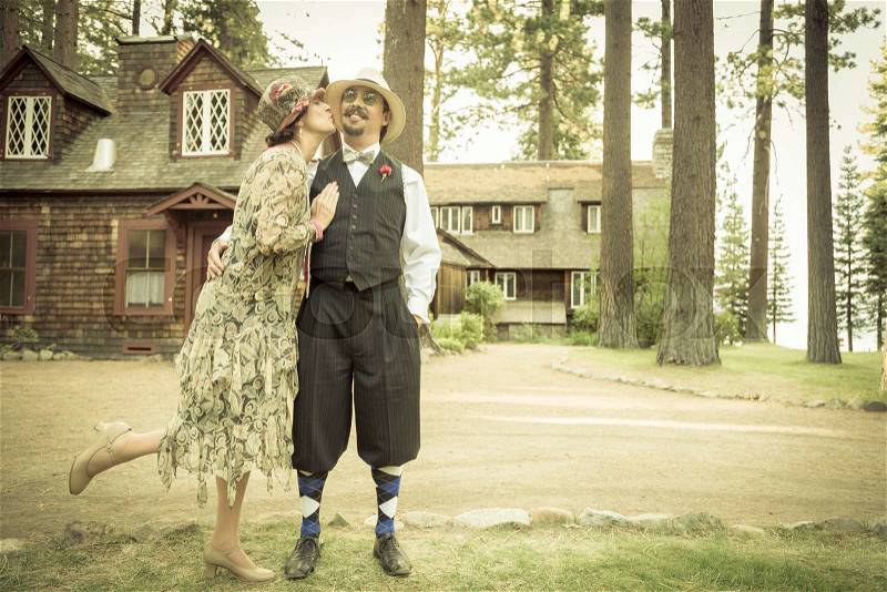 Attractive 1920s Dressed Romantic Couple in Front of Old Cabin Portrait, stock photo