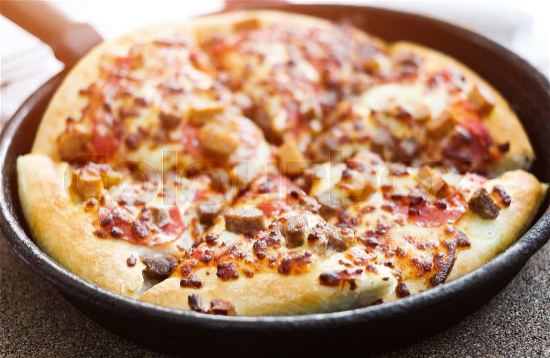 Cut delicious pizza in a pan, stock photo