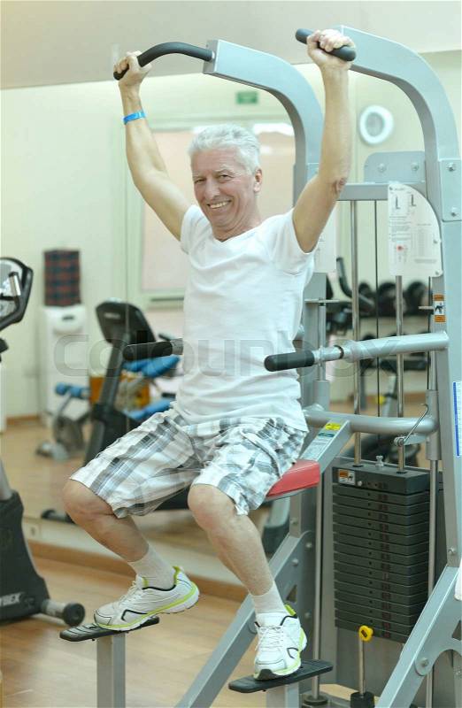 Elderly man in a gym during exercise, stock photo