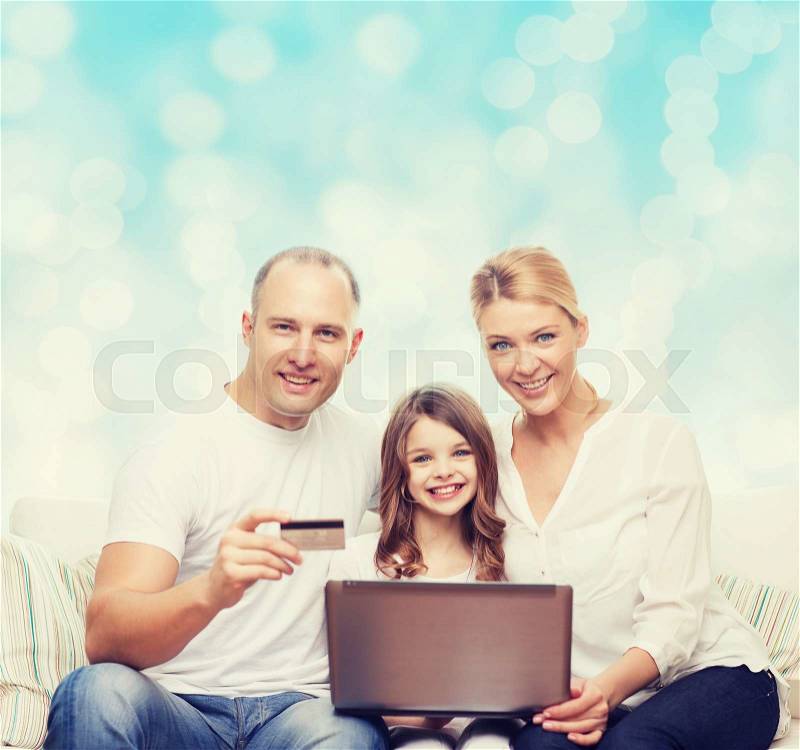 Family, holidays, shopping, technology and people concept - happy family with laptop computer and credit card over blue lights background, stock photo