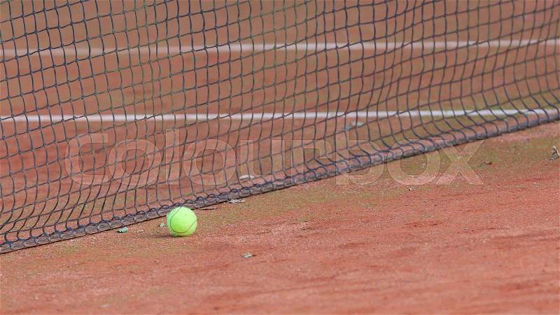 Gravel tennis court with tennis ball and net, stock photo