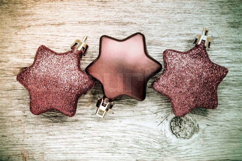 Christmas star baubles on the wooden background in vintage colors, stock photo