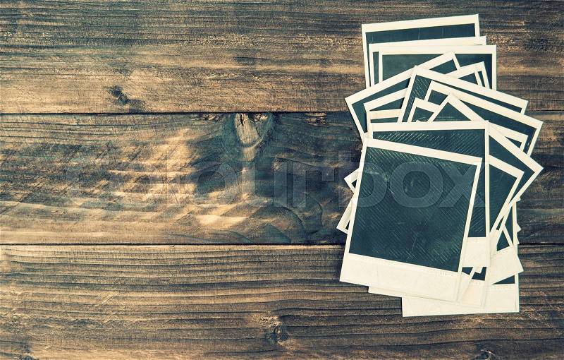 Old instant photo frames on rustic wooden background. Vintage style toned picture, stock photo