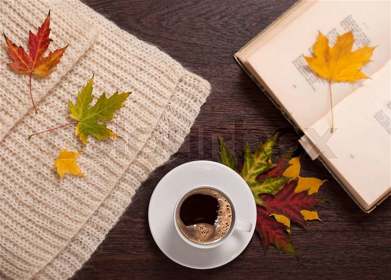 Coffee, open book, autumn leaves and wool scarf. Autumn concept, stock photo