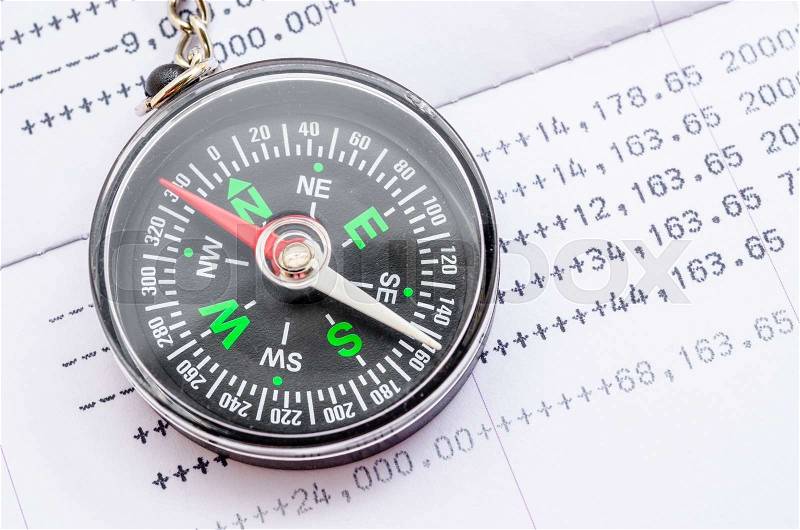 Compass and book bank statement. Financial direction concept, stock photo