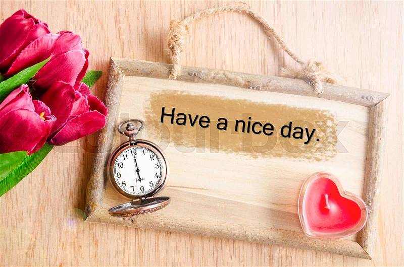 Have a nice day. Clock and red tulip with red candle heart shape on wooden background, stock photo