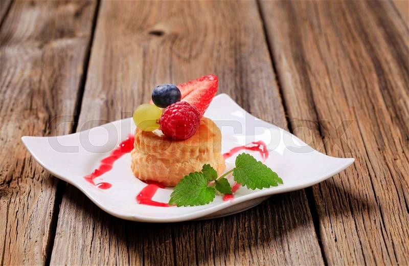 Custard filled puff pastry shell topped with fruit, stock photo