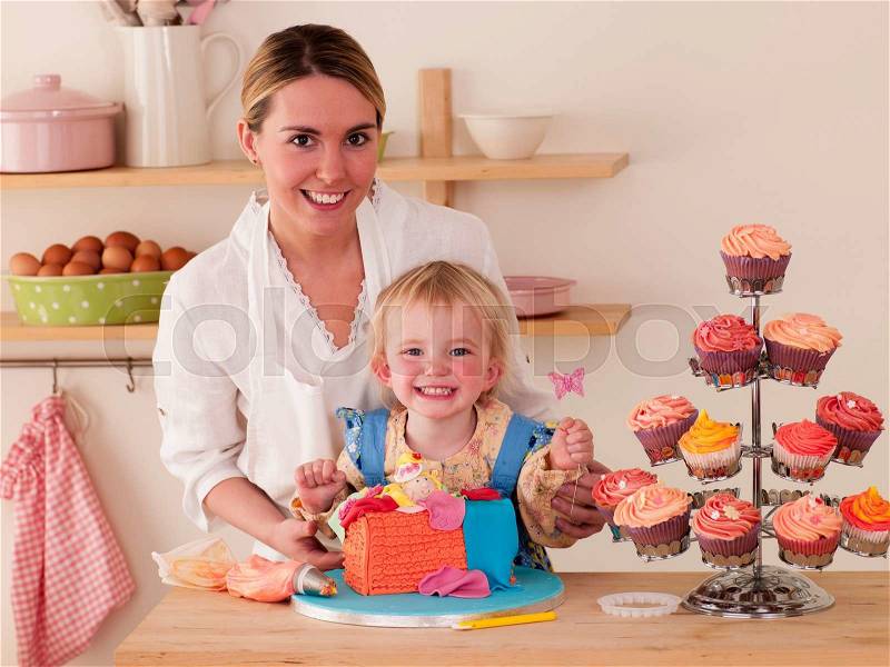 Mother and Daughter decorating cakes together, stock photo