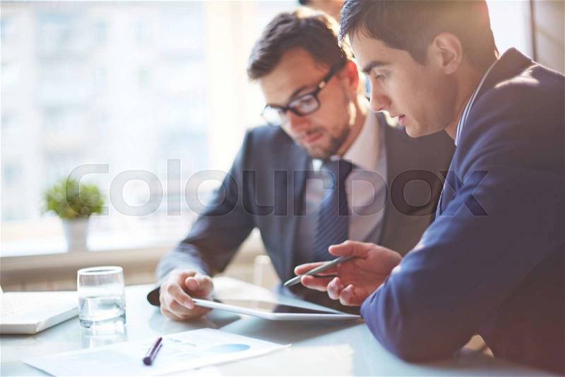 Young businessmen discussing data at meeting, stock photo
