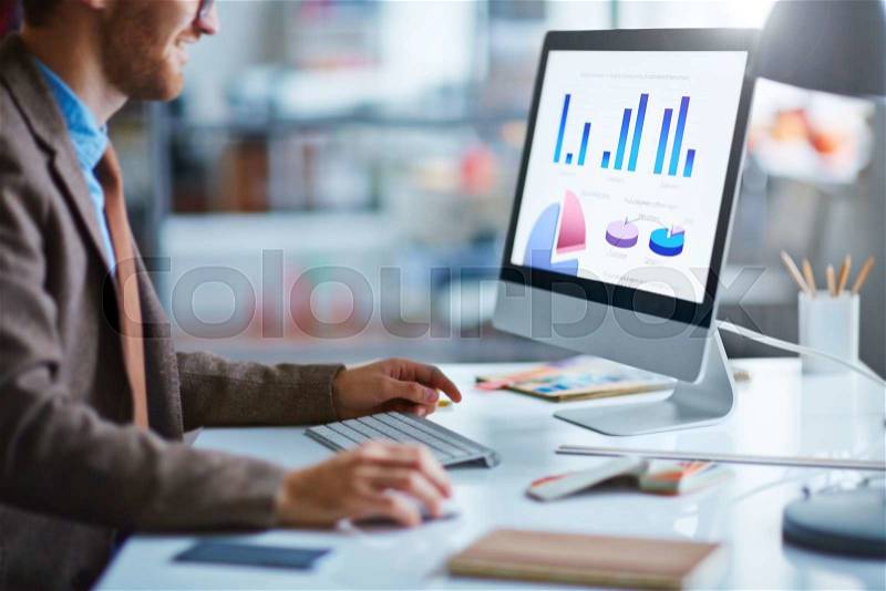 Young businessman working with electronic document in computer, stock photo