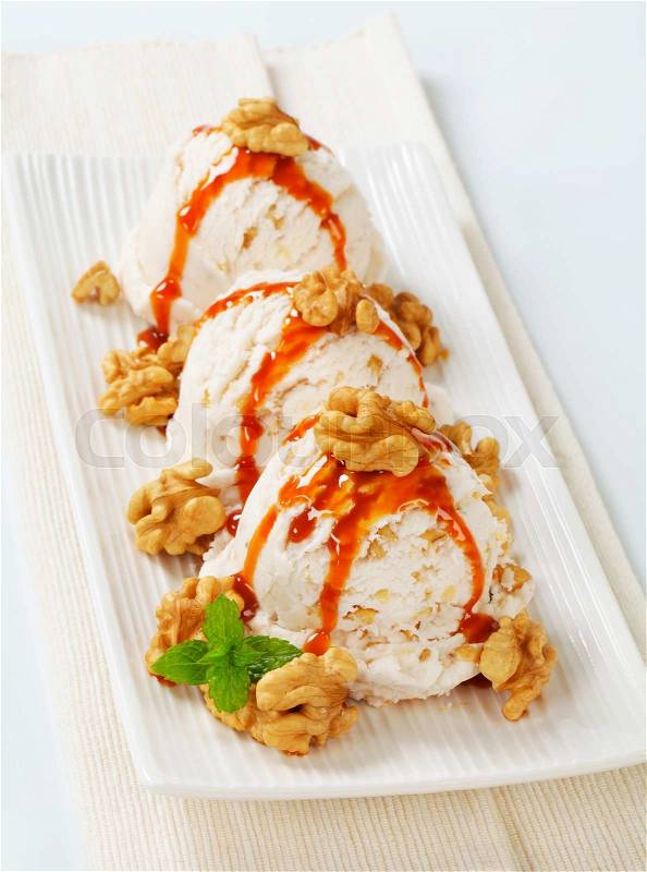 Scoops of walnut ice cream with caramel sauce, stock photo