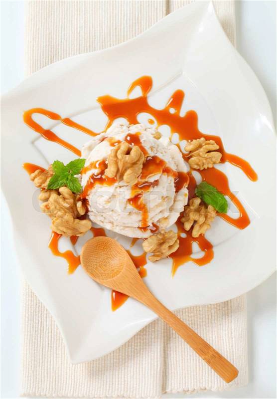 Scoop of walnut ice cream with caramel sauce, stock photo